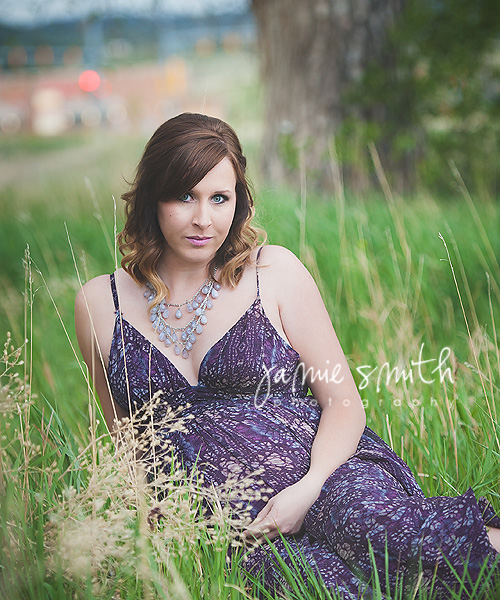 pregnant woman posing for her maternity session in tall grass