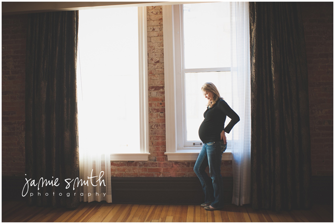 Pregnant woman posing by window