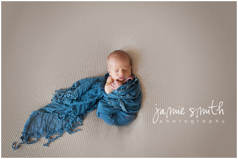 newborn boy swaddled in blue wrap