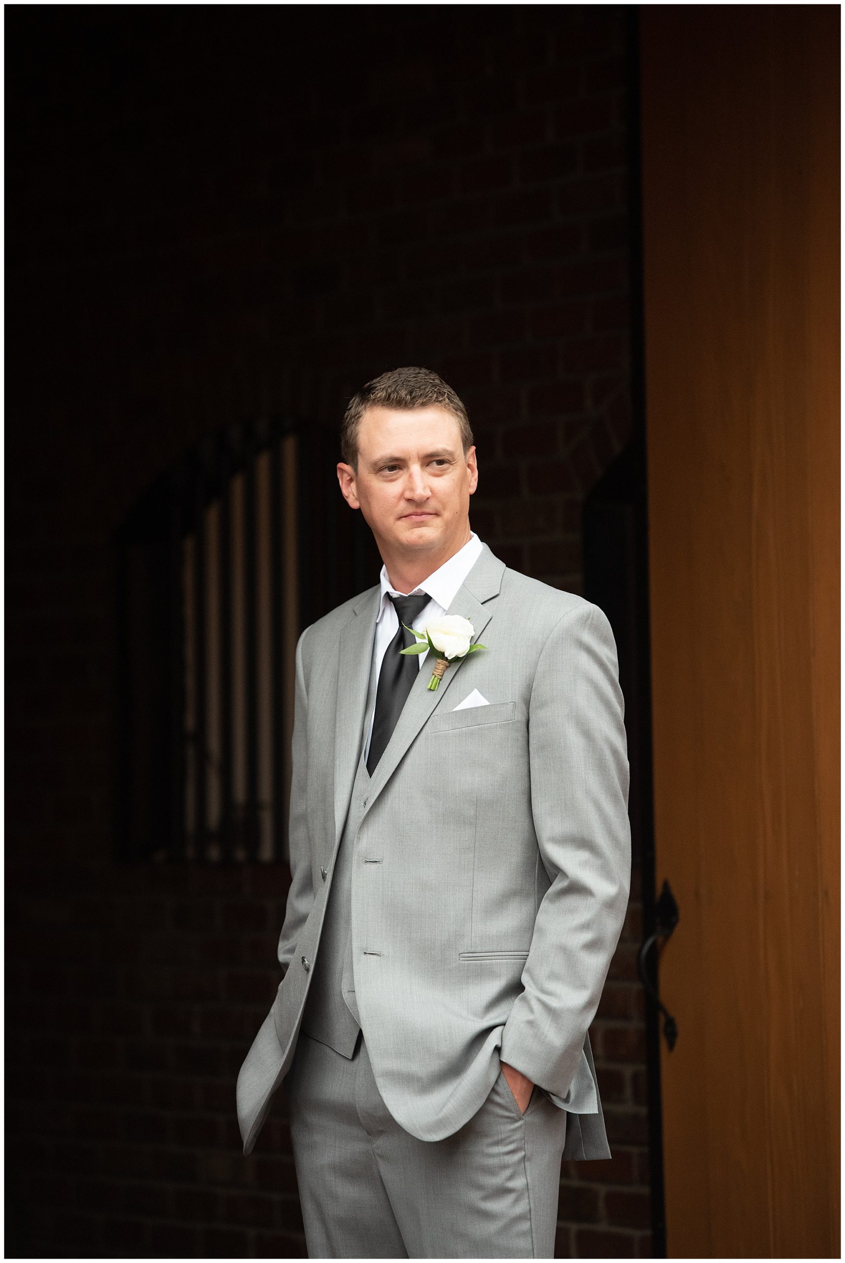 groom standing in the door of the barn at Crooked Willow Farms Wedding venue