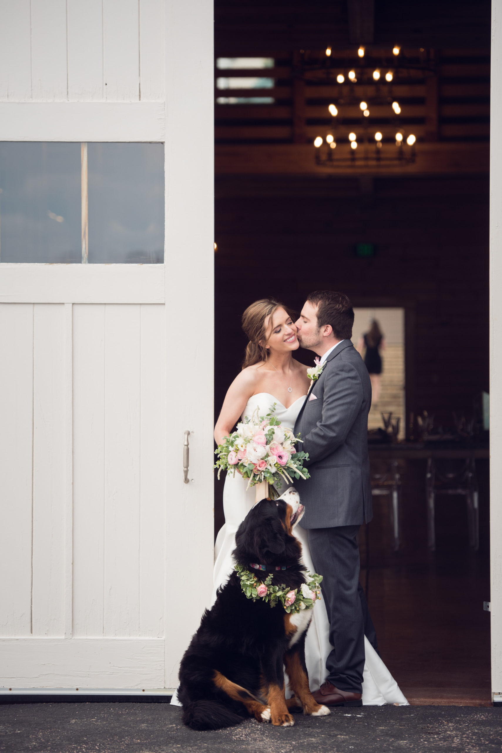 bride and groom sharing a kiss in the doorway of the barn at Flying Horse Ranch Wedding venue