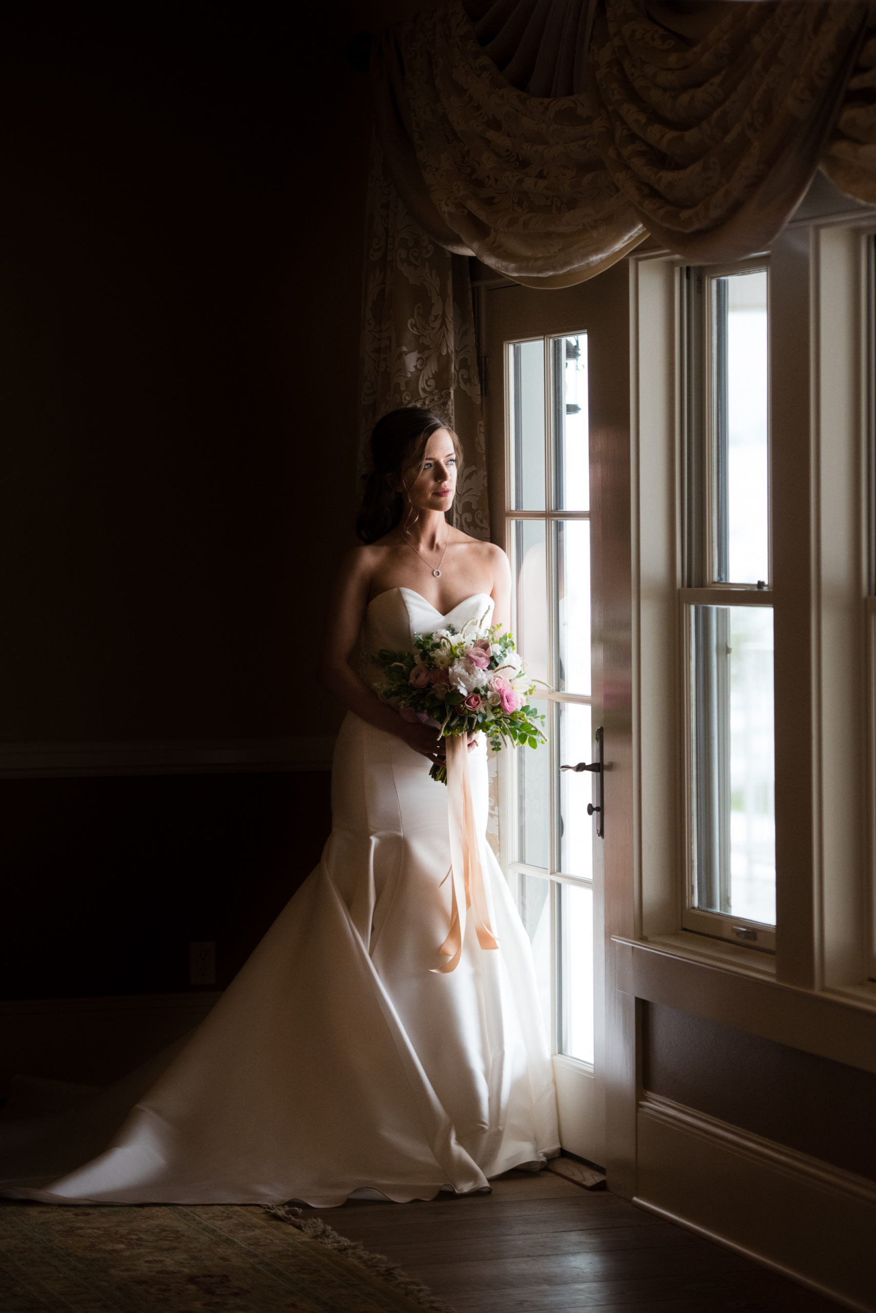 bride standing by an open window Flying Horse Ranch Wedding venue