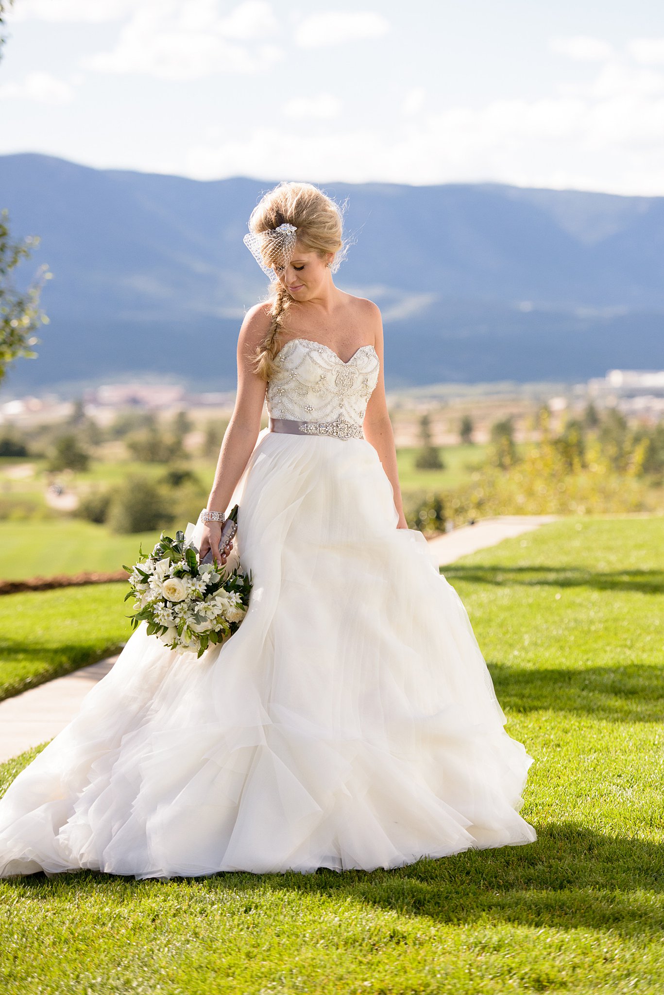 bride holding her bouquet with the Colorado Springs skyline behind her