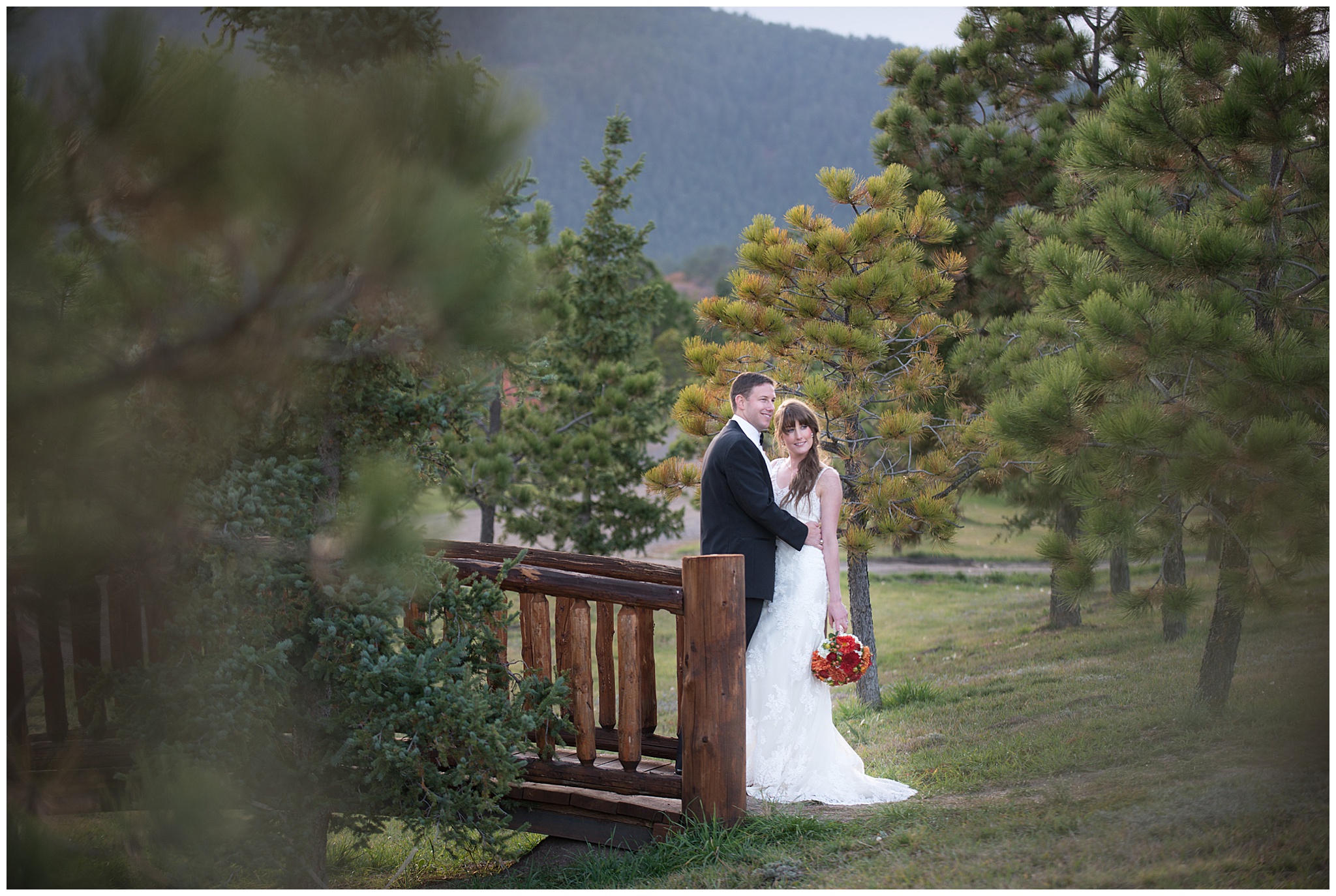 groom kissing his bride on the forehead near the bridge at Spruce Mountain Ranch Wedding venue