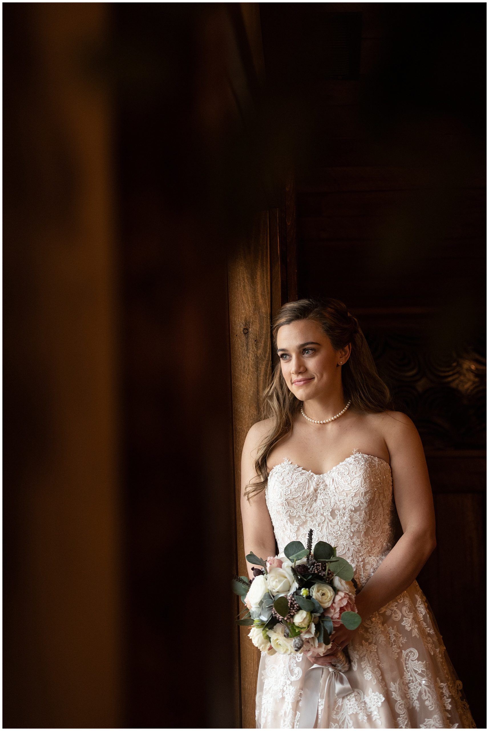 bride leaning against a column at Spruce Mountain Ranch Wedding venue