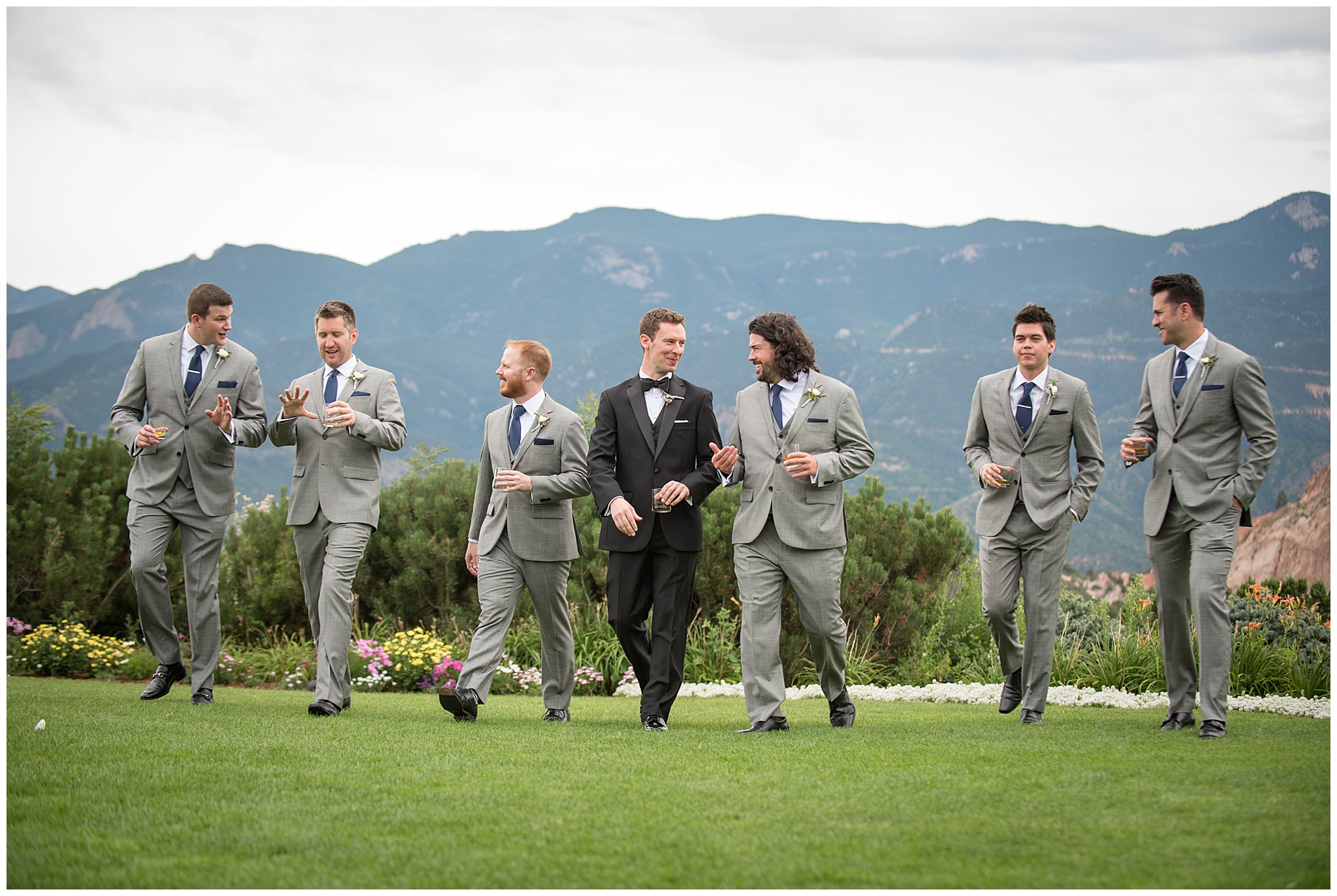 groom and his groomsmen walking along the golf course of the garden of the gods club wedding venue