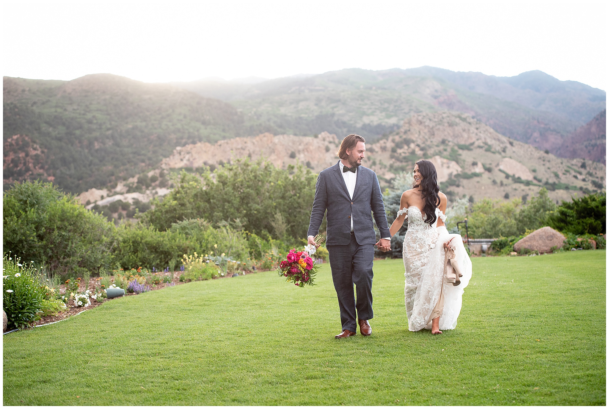 bride and groom walking across the lawn at the garden of the gods club wedding venue