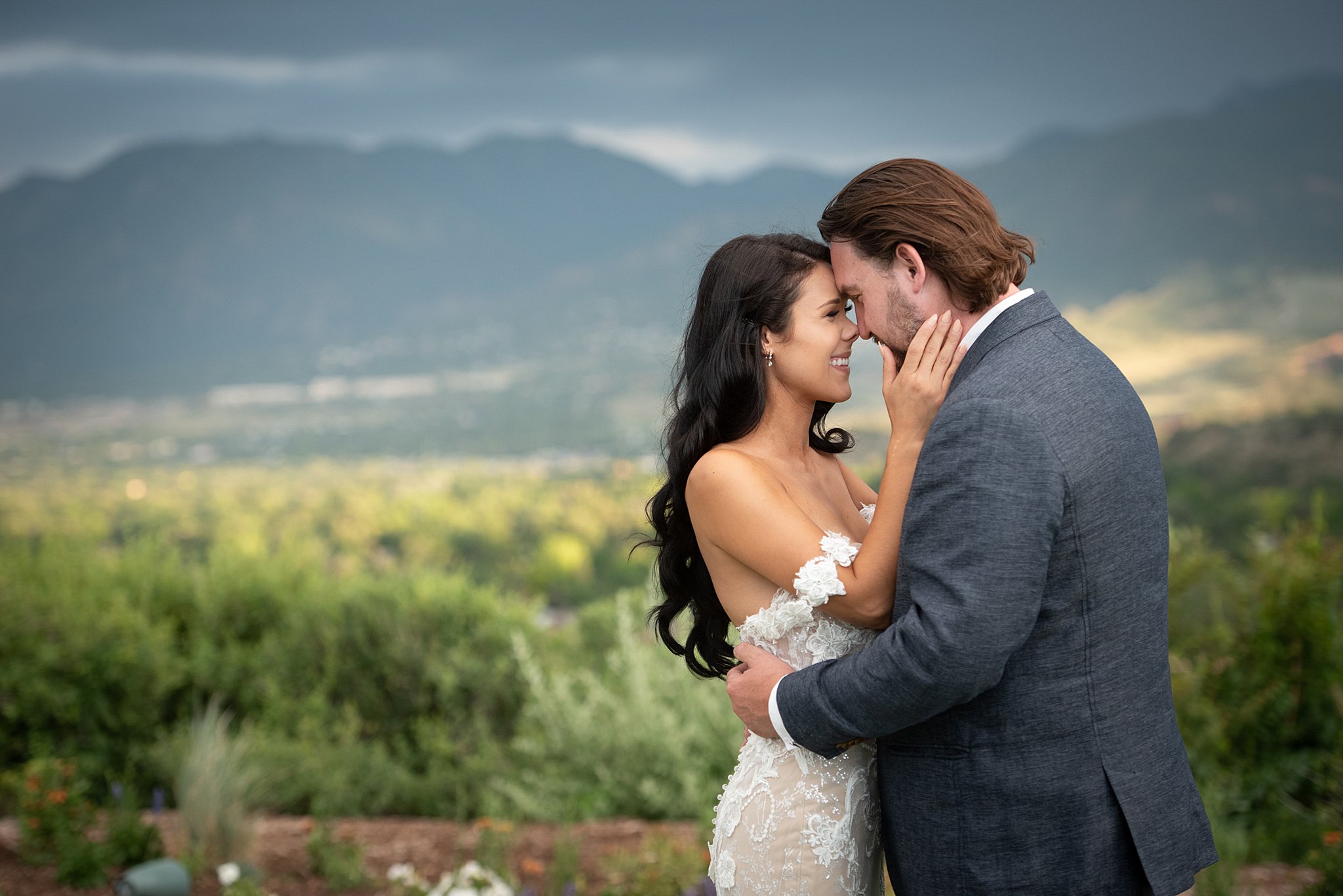 A happy bride boops noses with her groom in a garden at their wedding