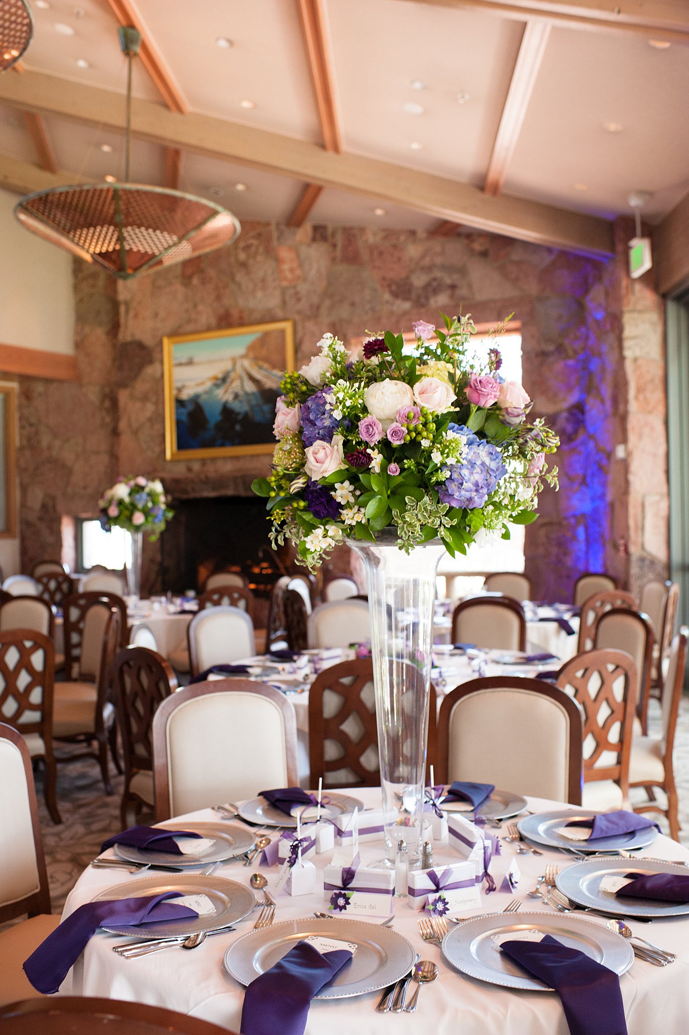 Details of a Garden Of The Gods Club Wedding reception centerpiece with purple knapkins and white linen