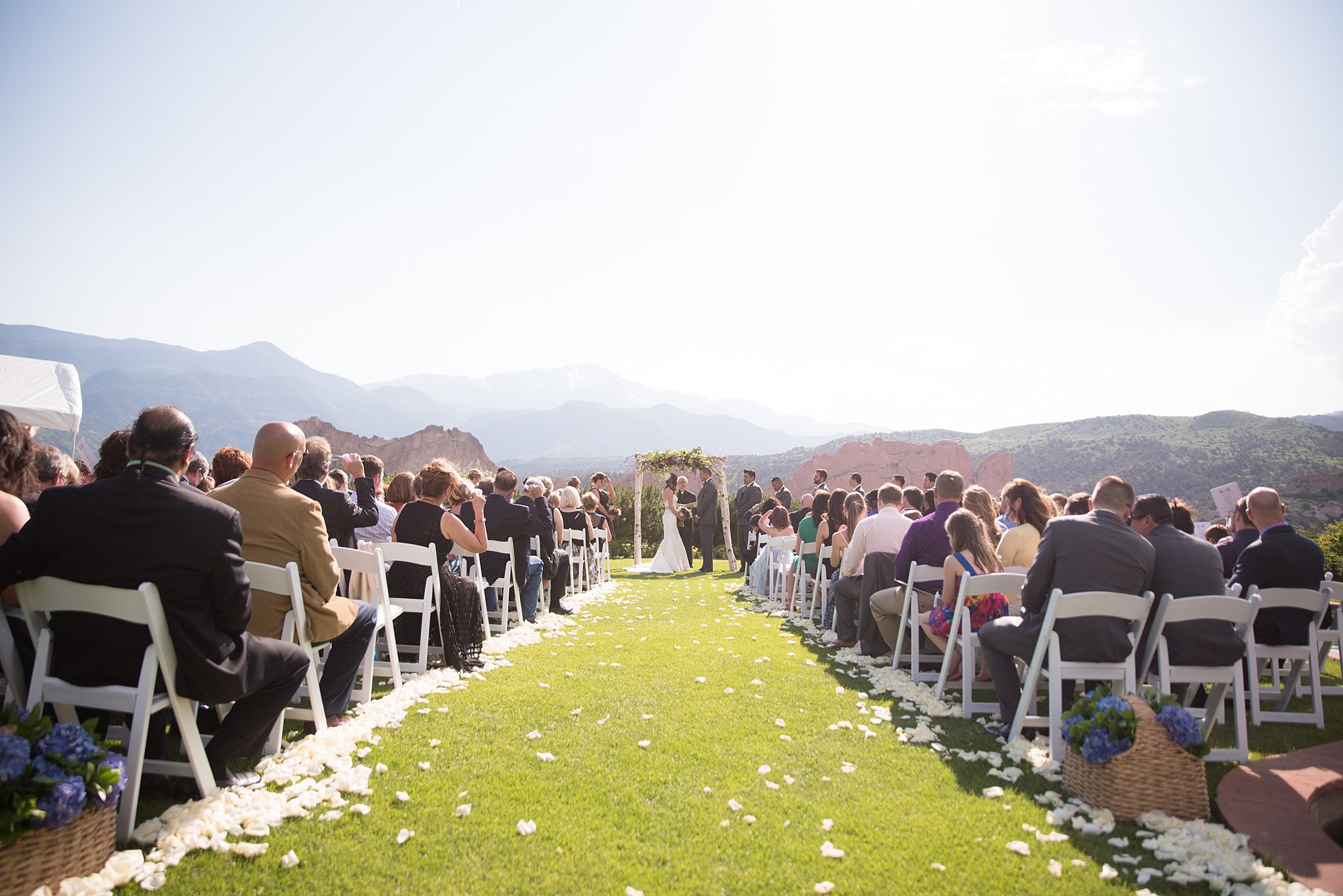 A peek down the aisle during a Garden Of The Gods Club Wedding ceremony on the lawn