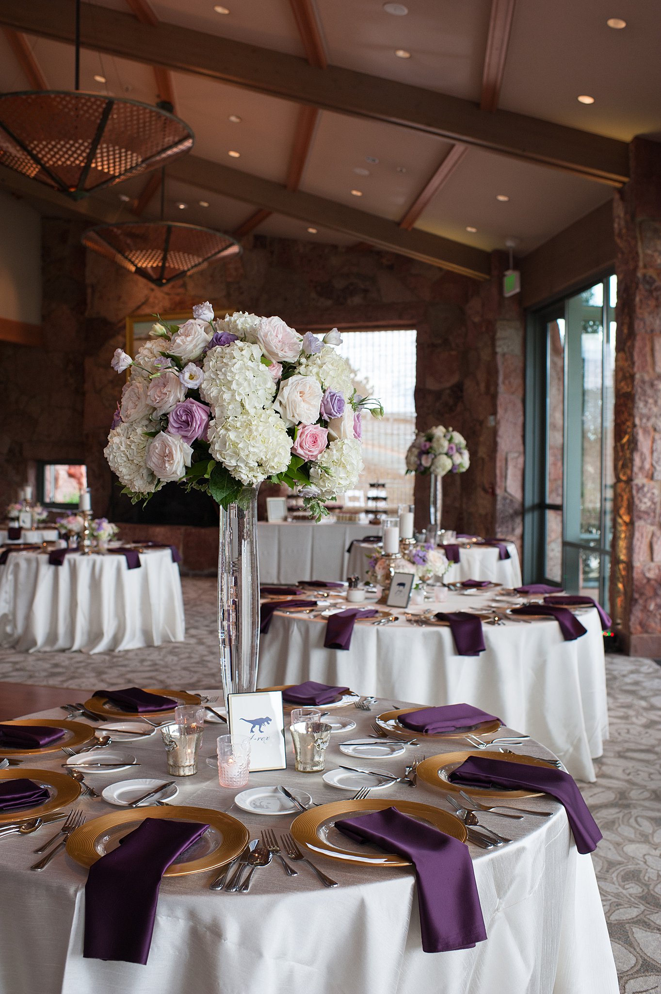 Details of a Garden Of The Gods Club Wedding reception with purple napkins and tall floral centerpieces