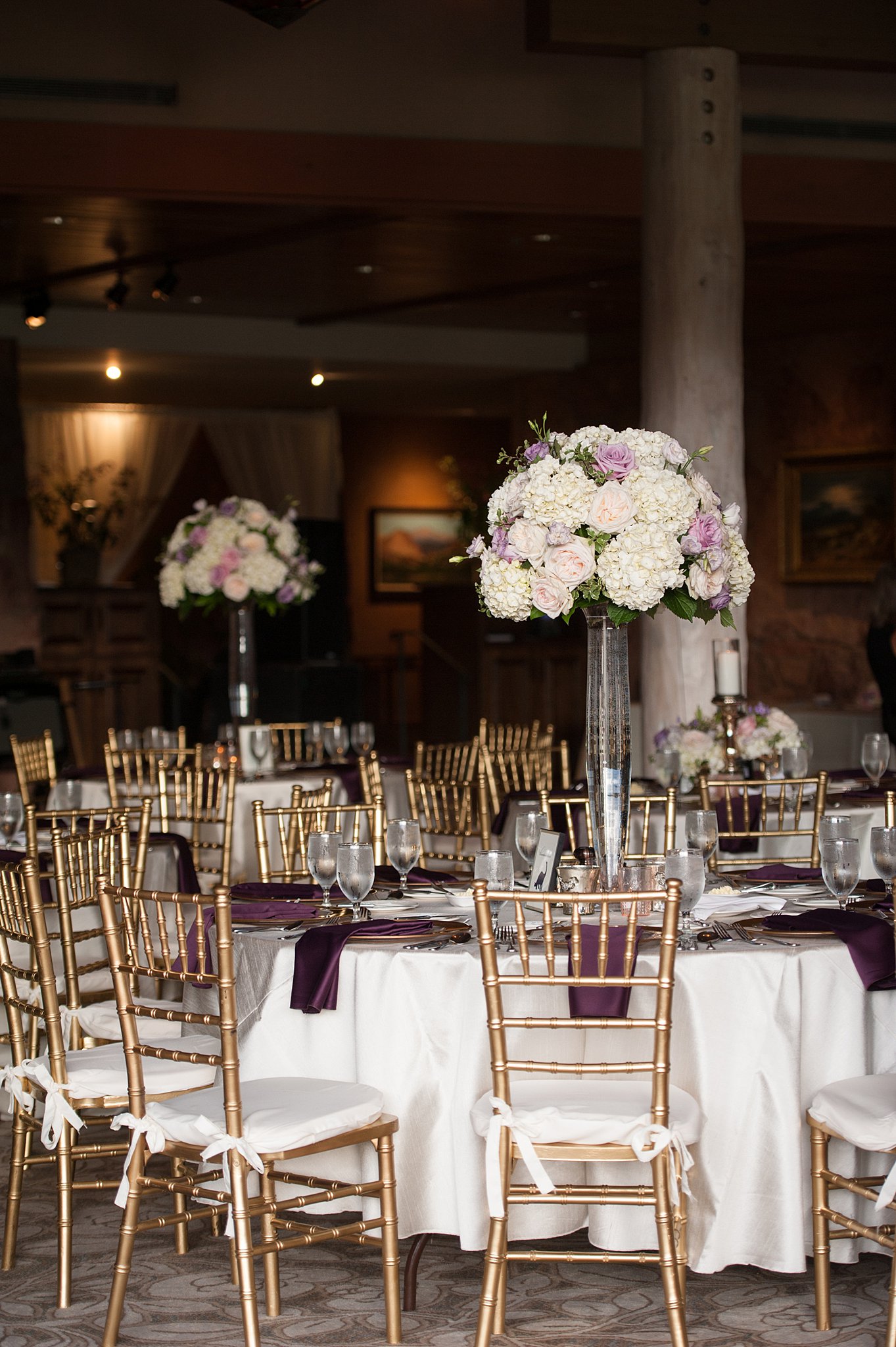 Details of a wedding ceremony set up with tall centerpieces and golden chairs