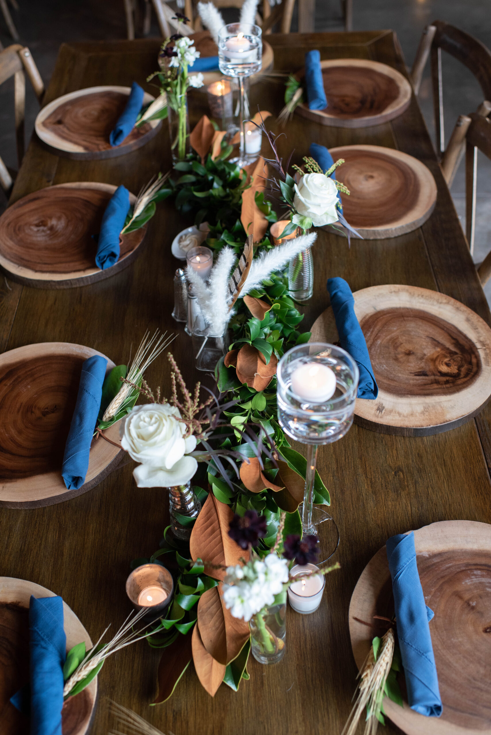 Details of a Spruce Mountain Ranch wedding ceremony with wooden chargers and blue napkins