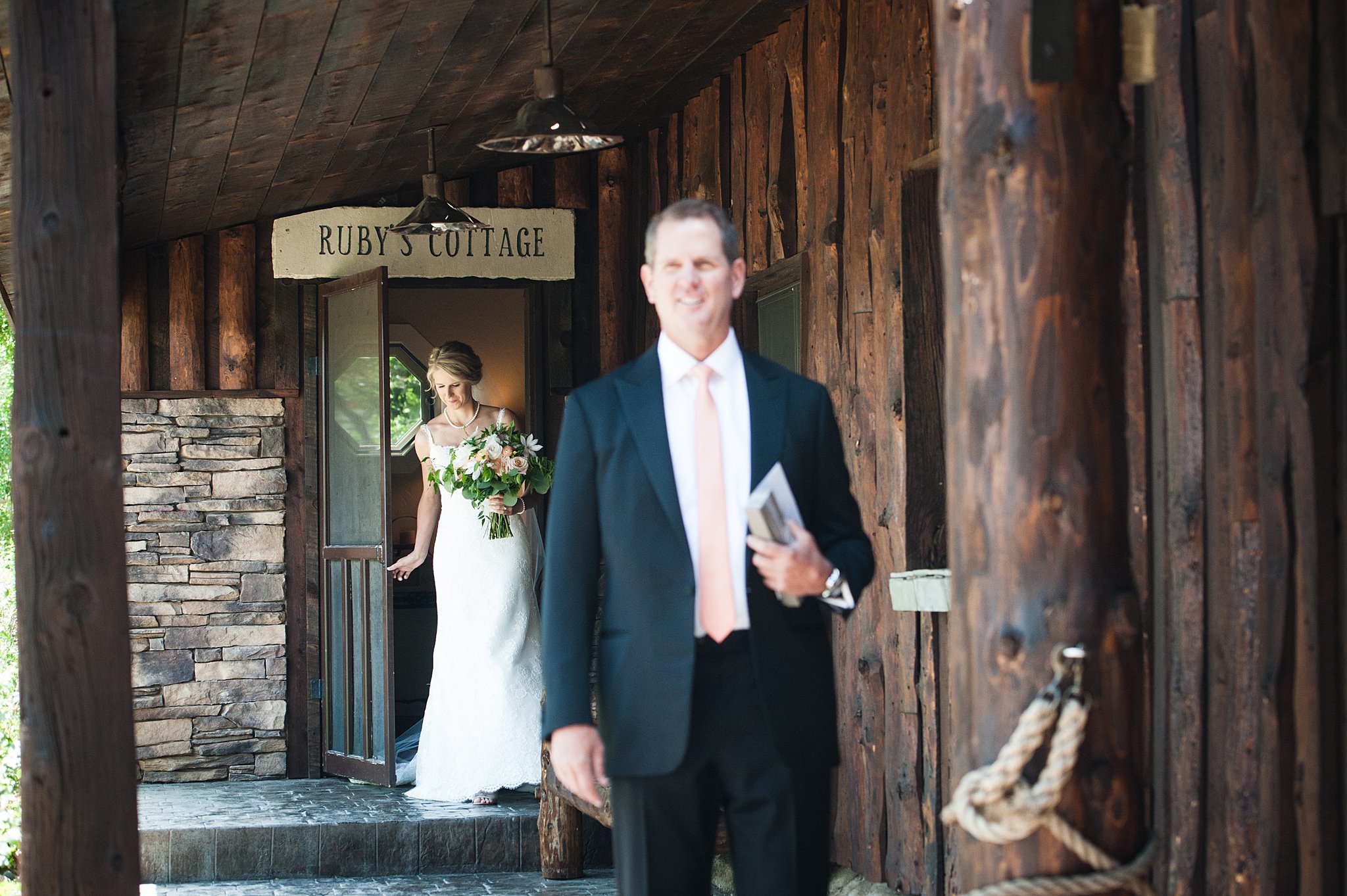 A dad waits on a porch as his daughter approaches in her wedding dress