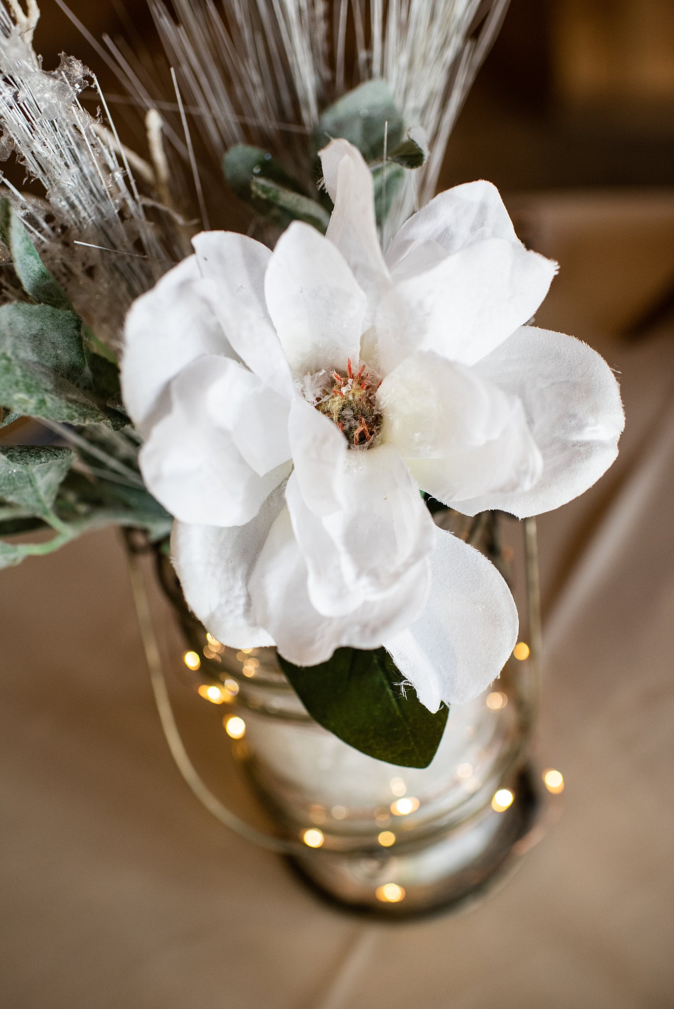 Details of a white flower on a table with lights on it