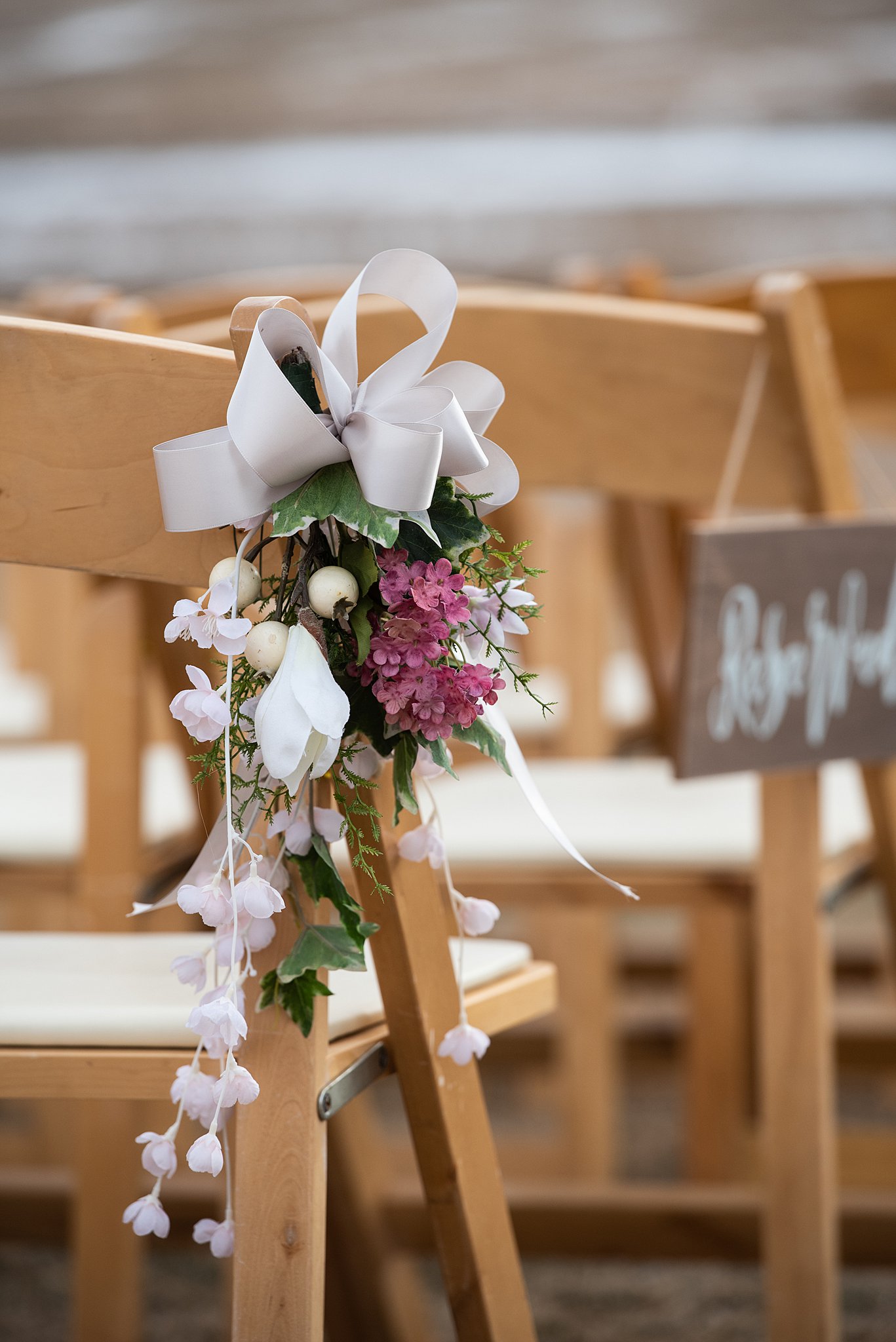 Details of a purple and white flower arrangement on a wooden chair for a ceremony