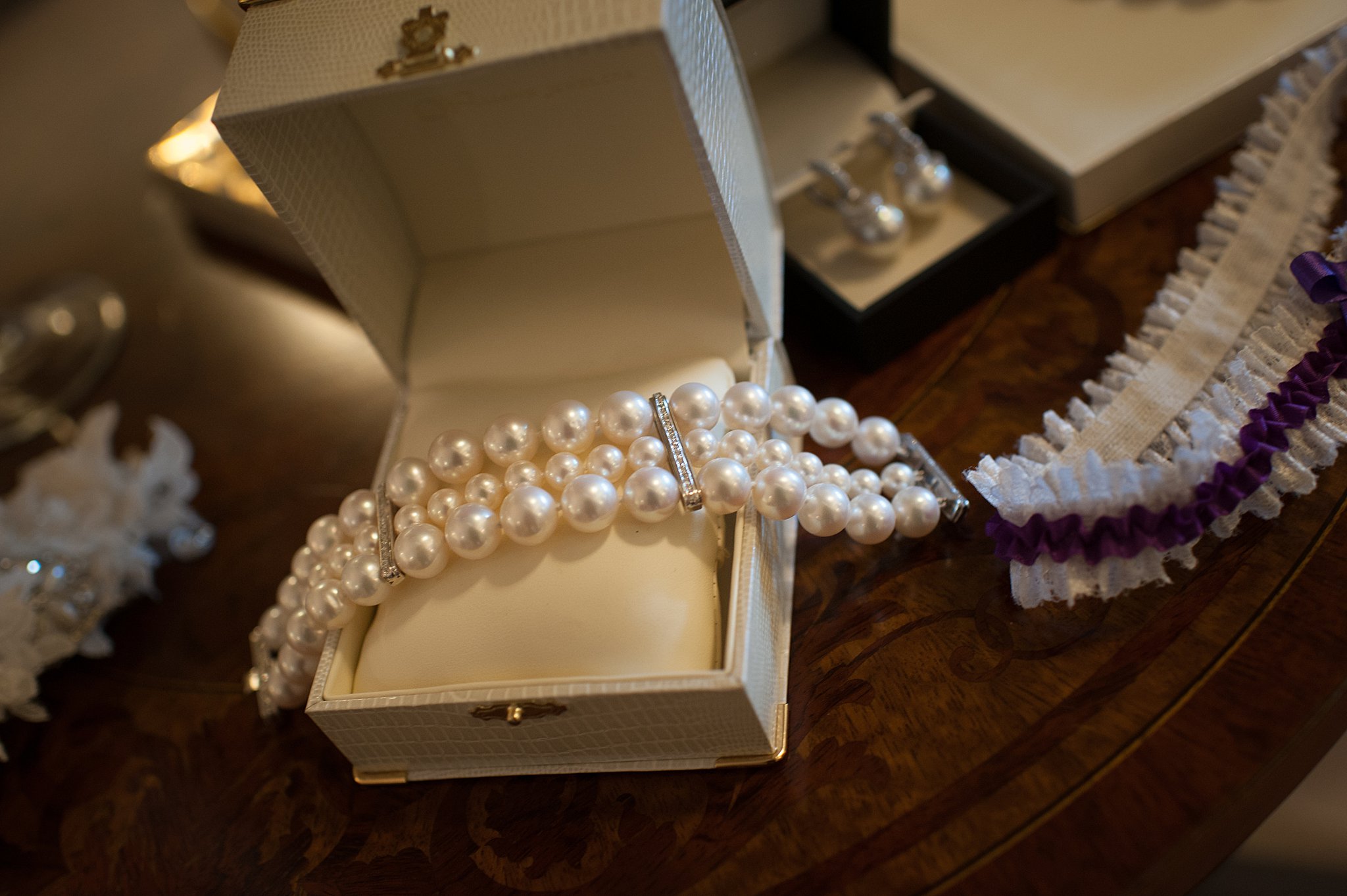 Details of a bride's pearl jewelry on a table