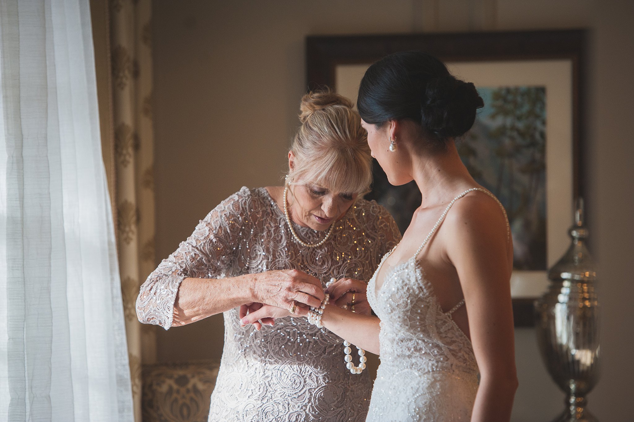 Mom helps a bride put on her pearl bracelet before her The Broadmoor Wedding