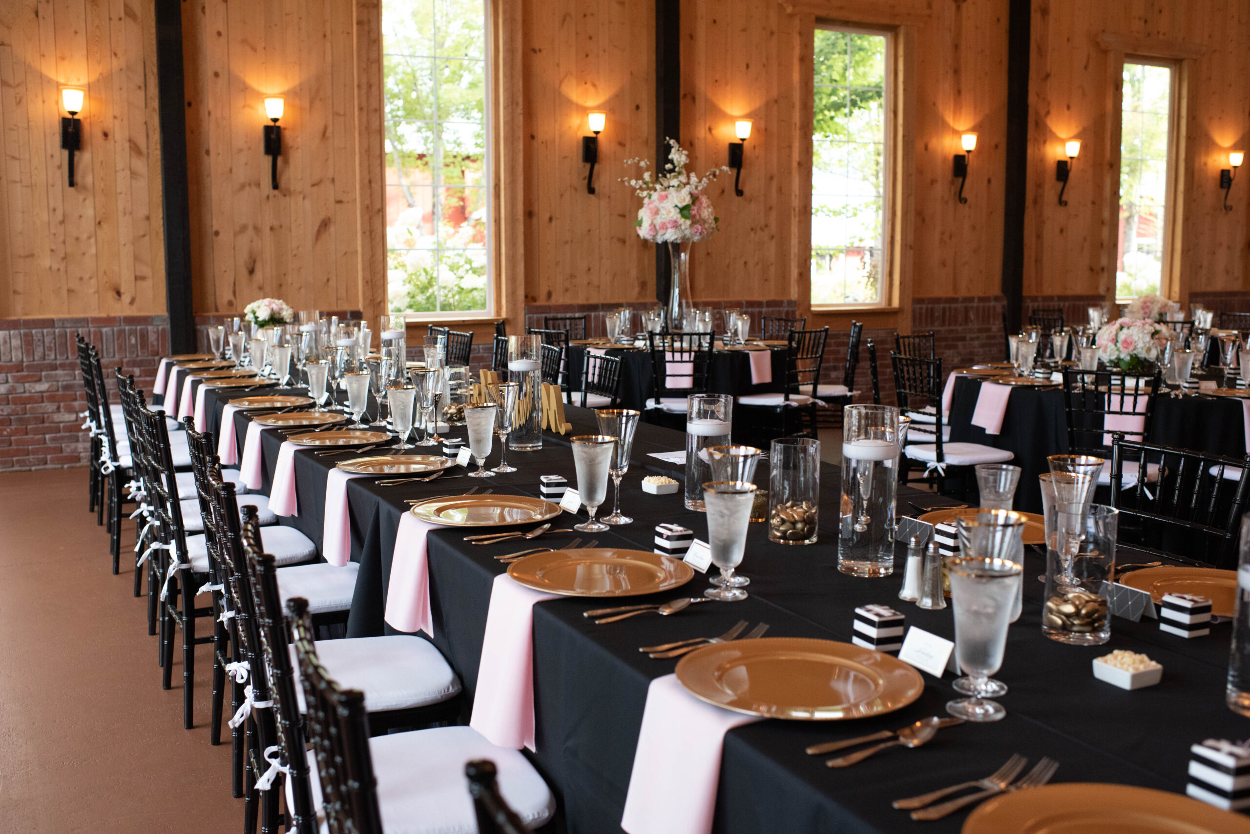 Details of long tables set up with black linen and pink napkins at The Venue At Crooked Willow Farms Wedding