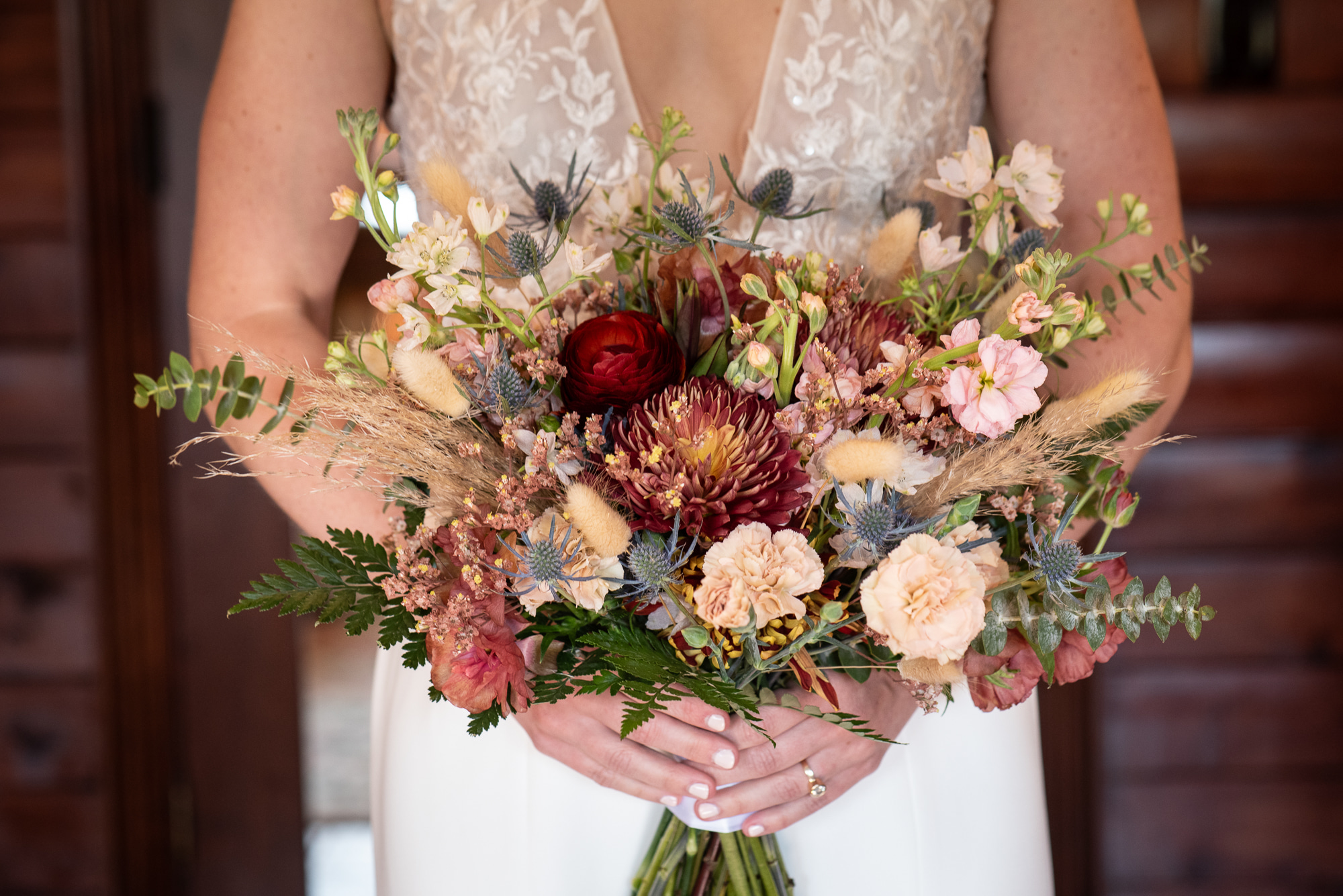 Details of a bride's vibrant bouquet as she holds it in front of herself