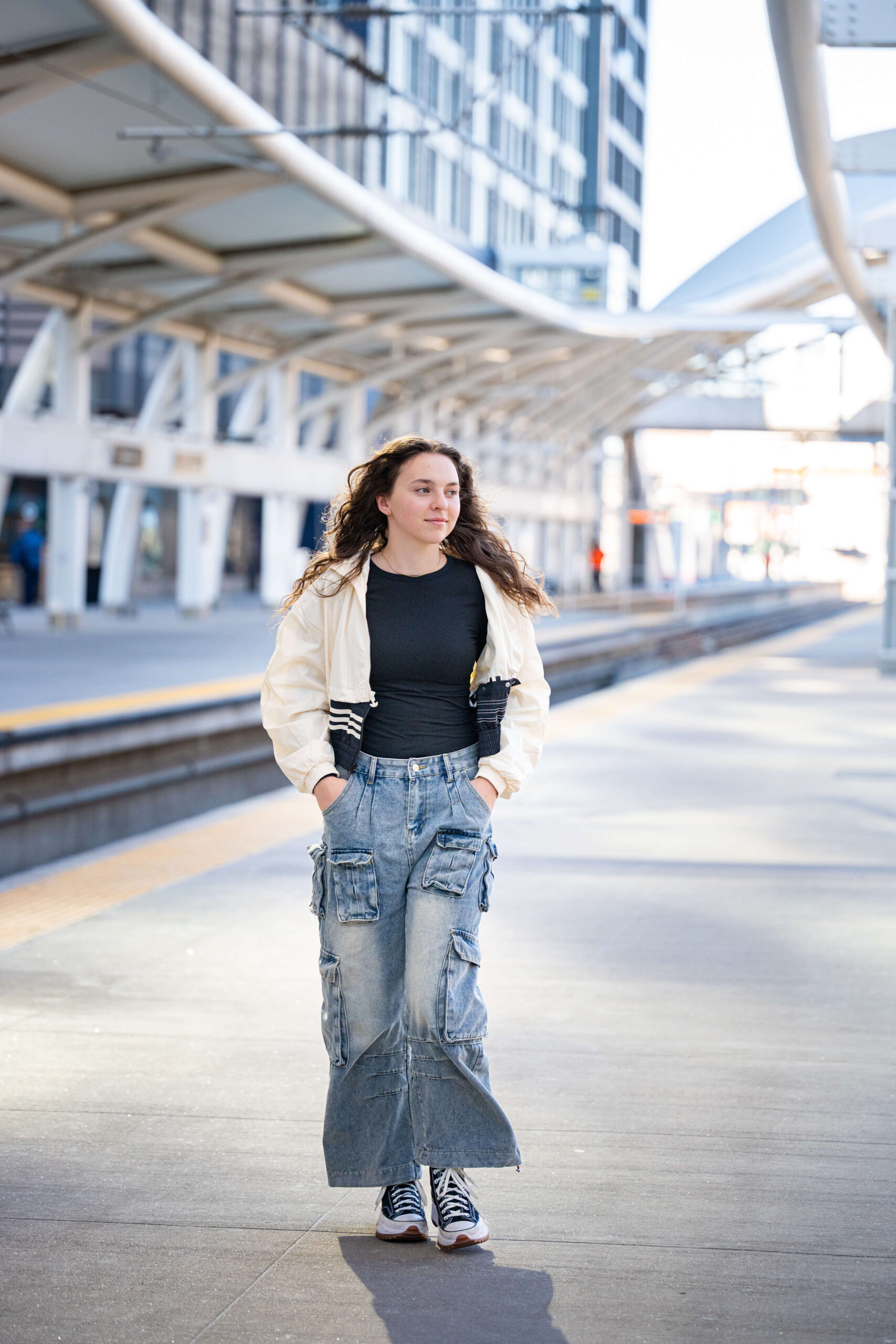 A high school senior walks on the concrete of an outdoor train station at a college fair in colorado springs.